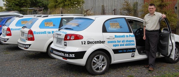 Economic Development officer Gary Gabbitas with the council vehicles promoting the Russell to Paihia Sovereign Ocean Swim event.